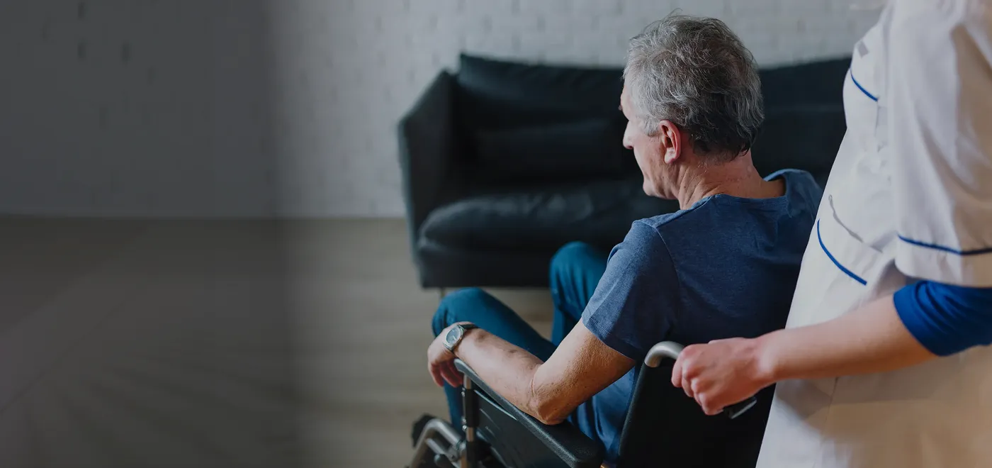 Caregiver supporting an older adult using a wheelchair